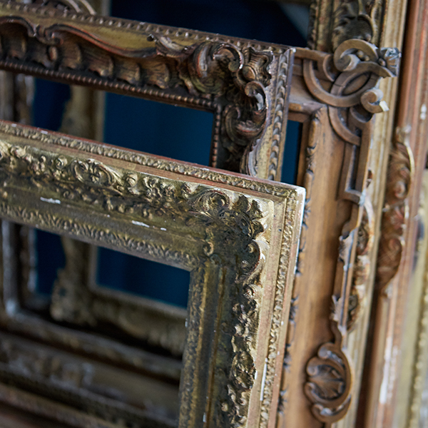 a stack of antique wooden picture frames