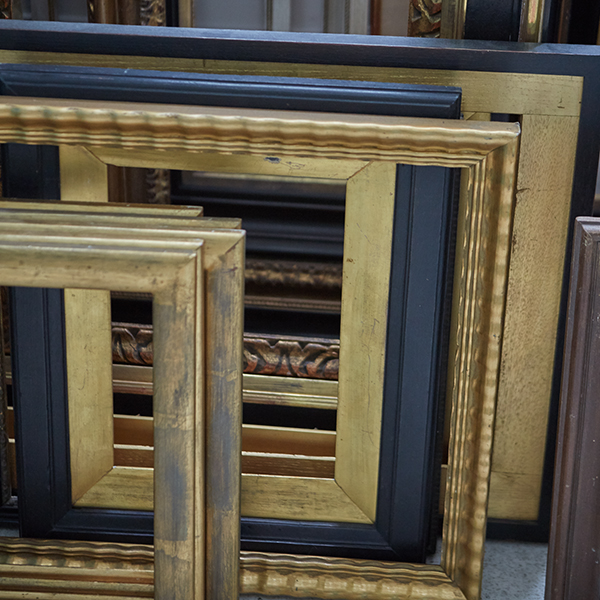a stack of varying antique wooden picture frames